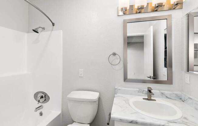 A white toilet sits next to a white sink in a bathroom.