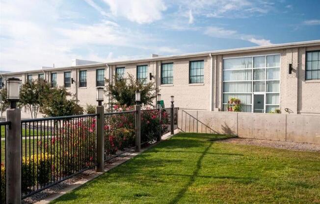 an apartment building with a yard and a fence