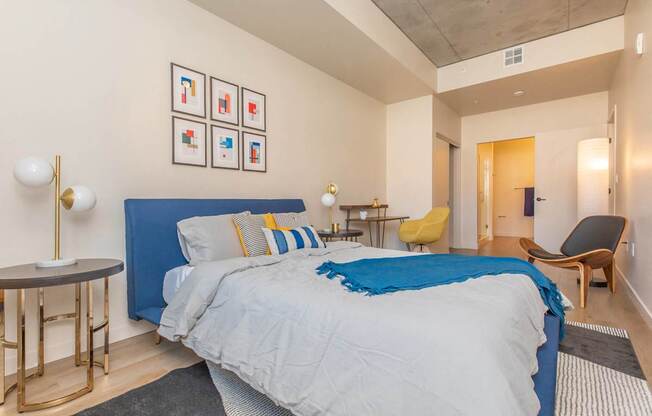 A bedroom with a blue bedspread and a bed with a blue headboard.