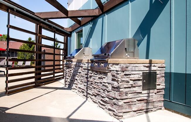a patio with a grill and a wooden fence