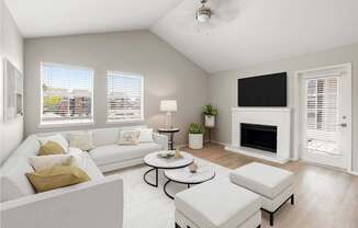 Bright living room with vaulted ceiling, fireplace, large windows, and soft neutral finishes.