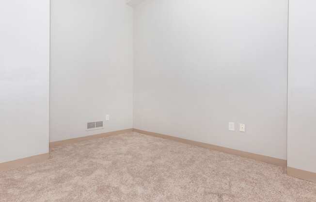 an empty room with a carpeted floor and white walls