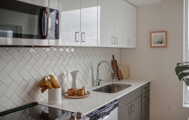 Kitchen with stainless-steel appliances, quartz countertops and subway tile backsplash