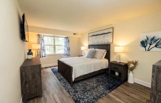 Primary bedroom with a queen bed, dresser, and window in Randallstown, MD 21133.