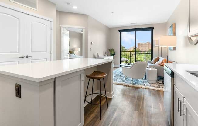 a kitchen with white cabinets and a white island with a wooden stool