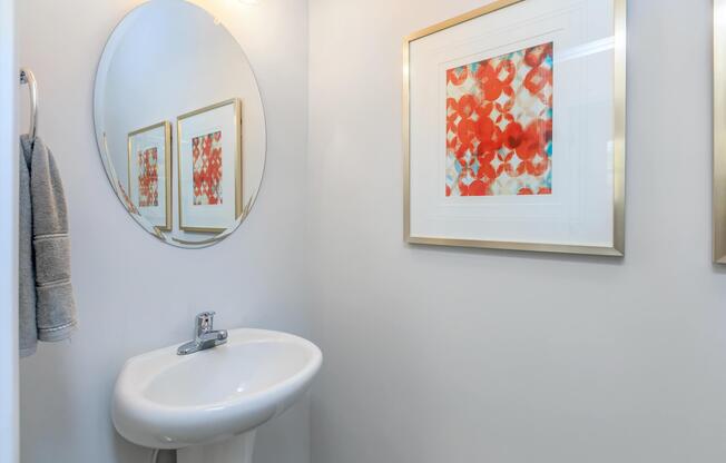 a white sink sitting underneath a mirror in a room