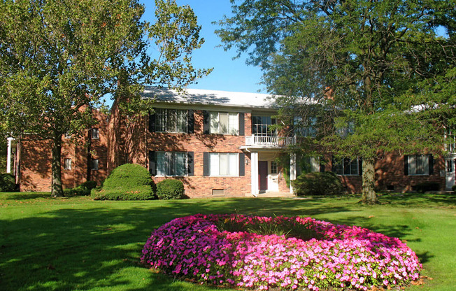 a bed of pink flowers in front of The Haven at Grosse Pointe apartment building