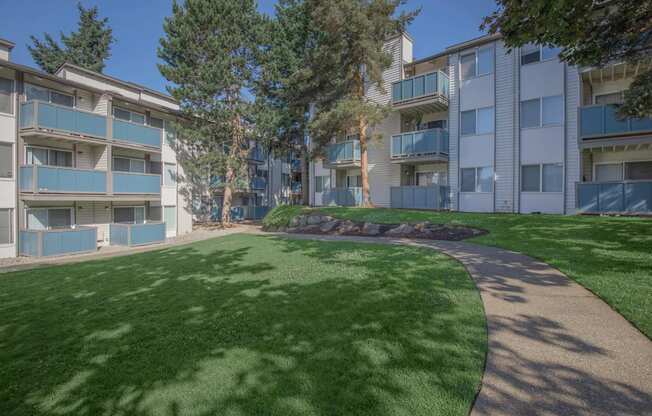 a grassy area with trees in a courtyard space at pet-friendly apartments in Tukwila