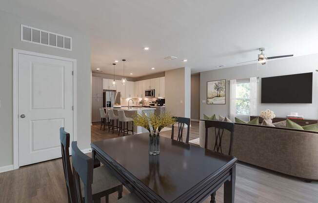 A modern dining room with a dark table and chairs.