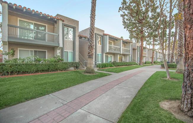 a path with grass in front of a building