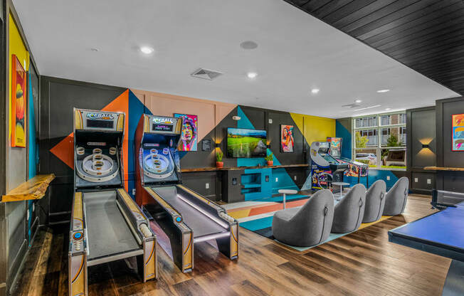 a game room with a bunch of arcade games and chairs