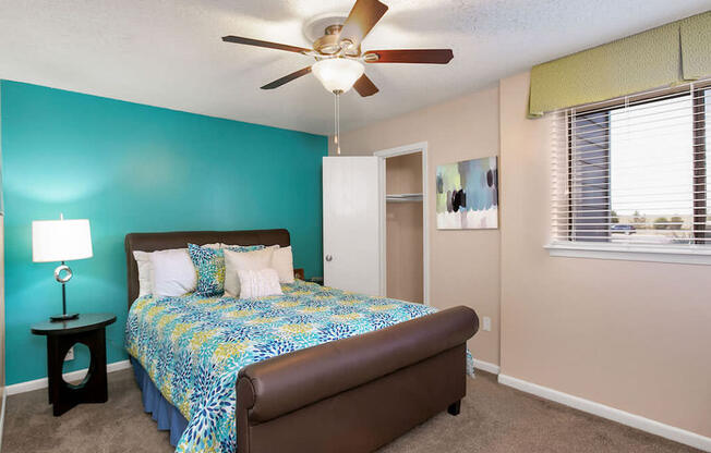 a bedroom with a bed and a ceiling fan
