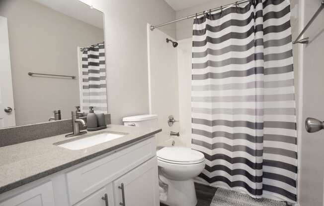 a white bathroom with a black and white shower curtain