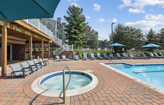 A pool surrounded by chairs and umbrellas.