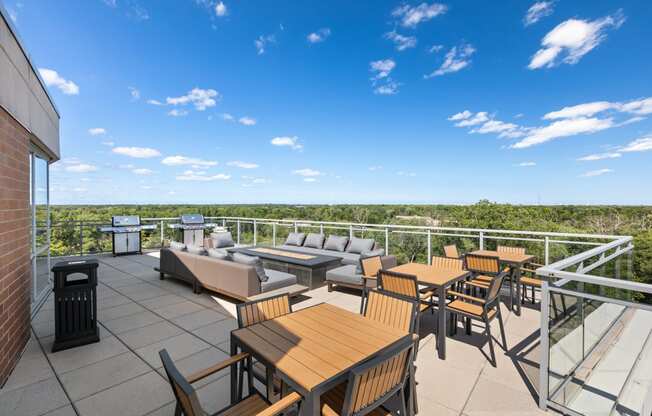 a patio with couches tables and chairs on a roof