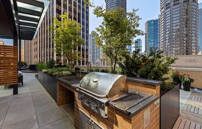 a barbecue grill on a patio with skyscrapers in the background