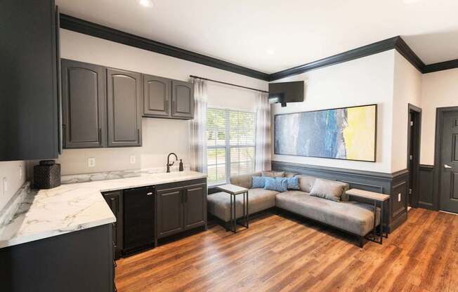 A kitchen with black cabinets and a marble countertop.