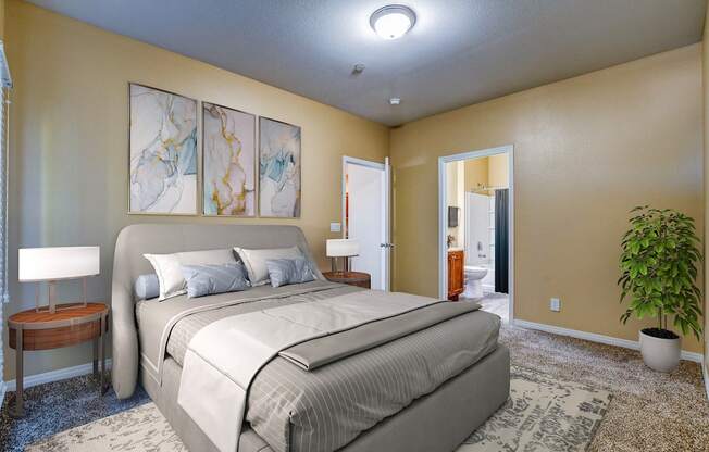 A bedroom with a large bed, a lamp, and a plant.