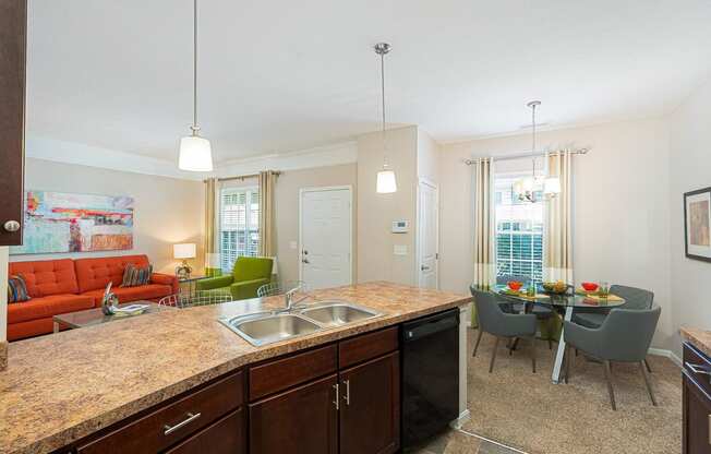 an open kitchen and living room with a dining room table and chairs