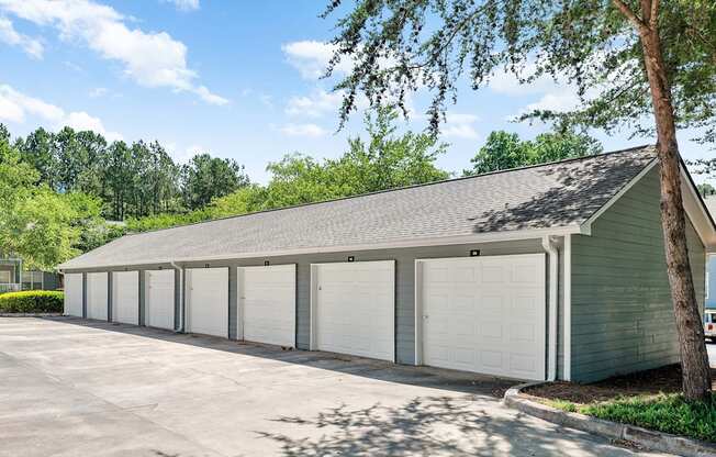 a row of garages with white doors on the side of a building