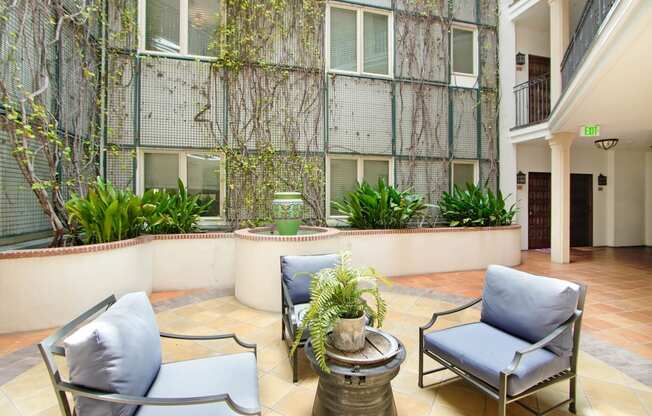 a patio with chairs and a table in front of a building