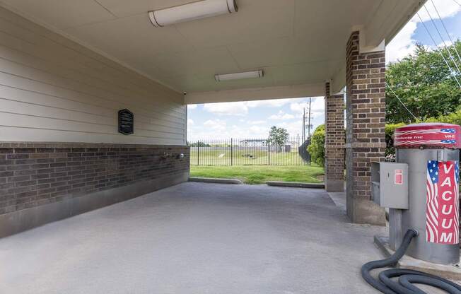 A vacuum cleaner is plugged into an outlet on a brick wall.