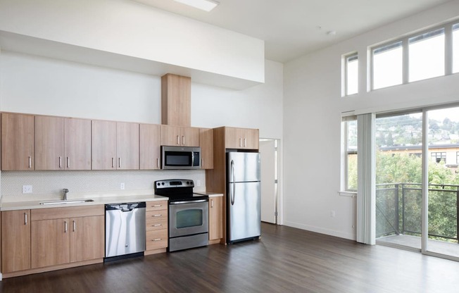 an empty kitchen with wooden cabinets and stainless steel appliances