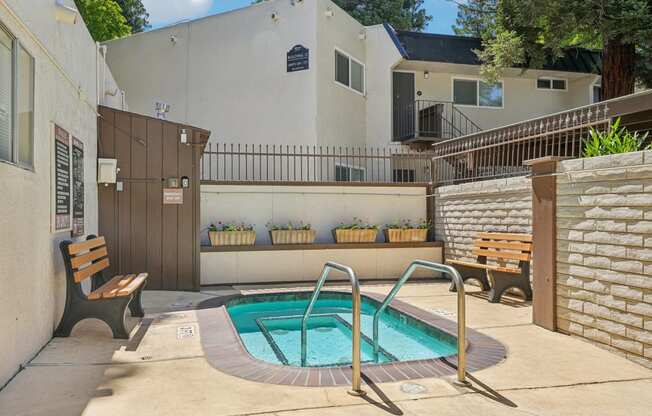 the pool is in the backyard of a house with a hot tub