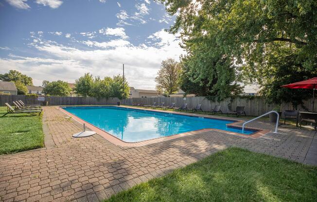 a large lawn in front of a pool of water