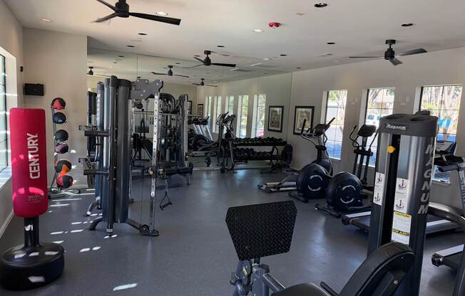 A gym with a variety of equipment including treadmills, weights, and exercise machines.