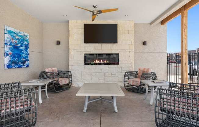 a patio with a table and chairs and a fireplace