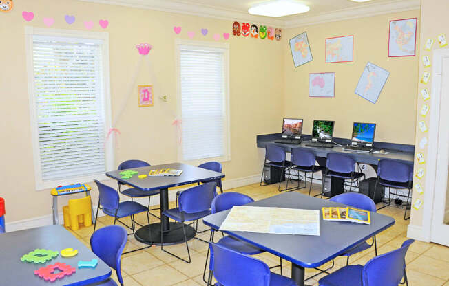 A classroom with tables and chairs and a whiteboard.