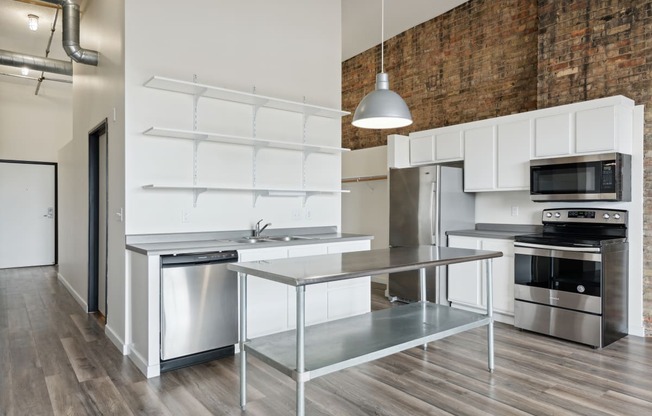 a kitchen with white cabinetry and stainless steel appliancesat Gaar Scott Historic Lofts, Minnesota, 55401