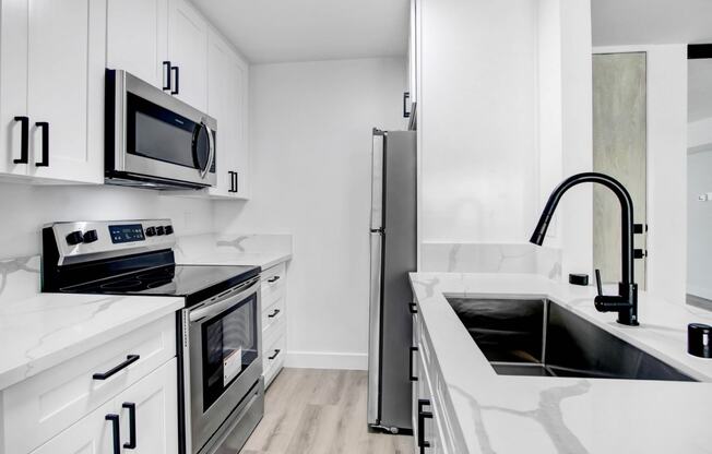 a kitchen with white cabinets and stainless steel appliances