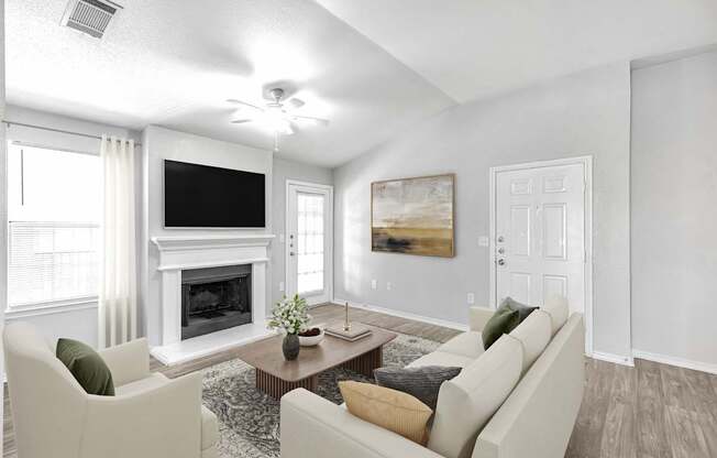 A living room with a fireplace, a television, and a painting.