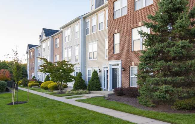 a brick apartment building with a sidewalk in front of it