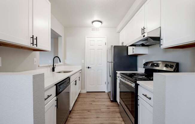 A kitchen with white cabinets and appliances.