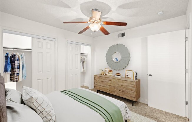 a bedroom with a ceiling fan and a closet