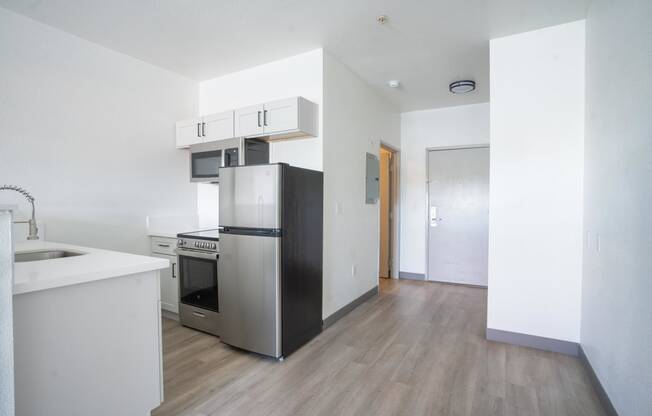 an empty kitchen with a refrigerator and a sink