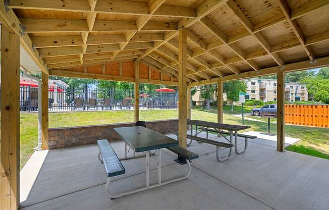 two picnic tables under a pavilion in a park