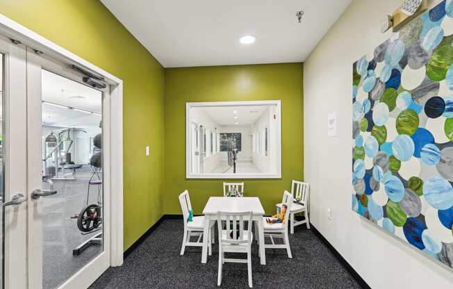 a dining room with a table and chairs and a painting on the wall