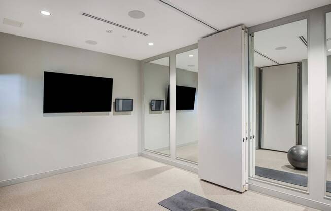 Yoga room with TV and mirrors