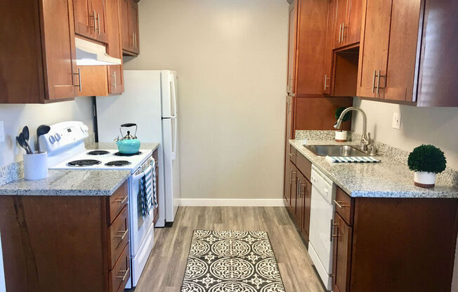 a kitchen with wooden cabinets and a white refrigerator at Element LLC, Sunnyvale, CA