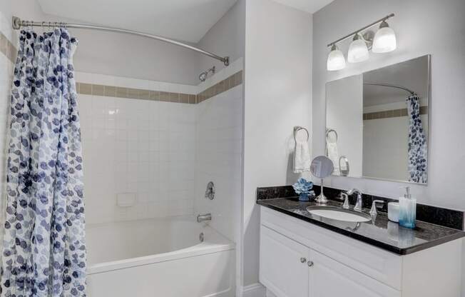 Bathroom with faux hardwood floors, white trim, neutral walls, and soaking tub.