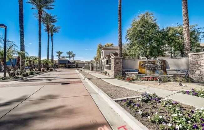 a sidewalk in front of a building with palm trees at Adiamo Palm Valley, Goodyear, AZ