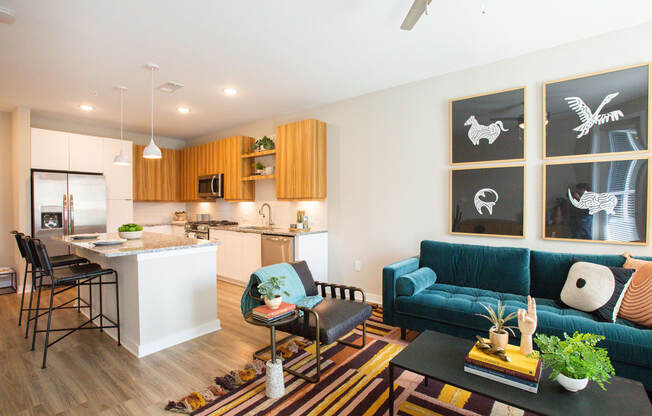 a living room with a blue couch and a kitchen with an island