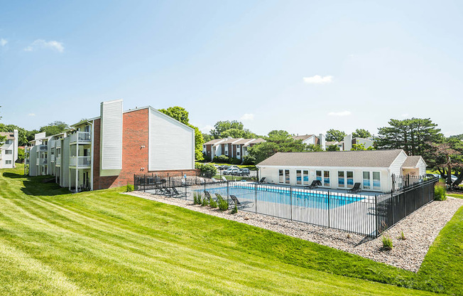 a large yard with a pool in front of some apartments