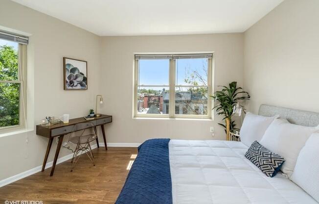 a bedroom with a large bed and two windows