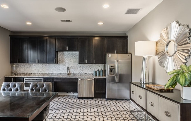 an open kitchen with stainless steel appliances and a dining table