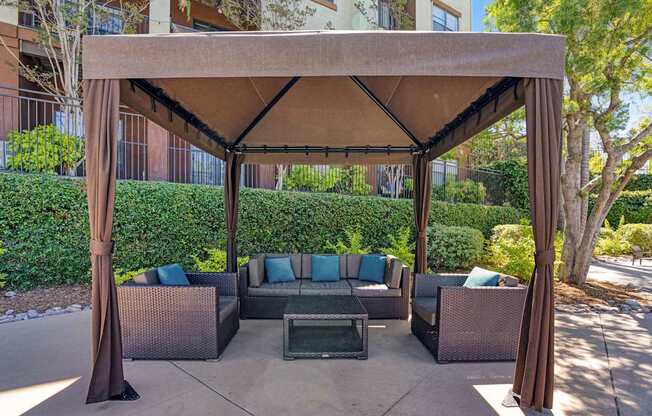 A patio with a couch and a table under a canopy.